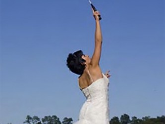 Bride jumping with a badminton racquet on our lawn